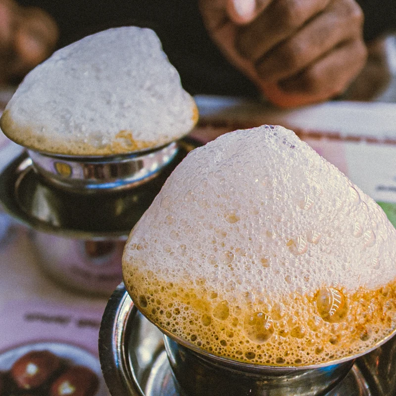Traditional South Indian filter coffee in stainless steel tumbler and dabarah set