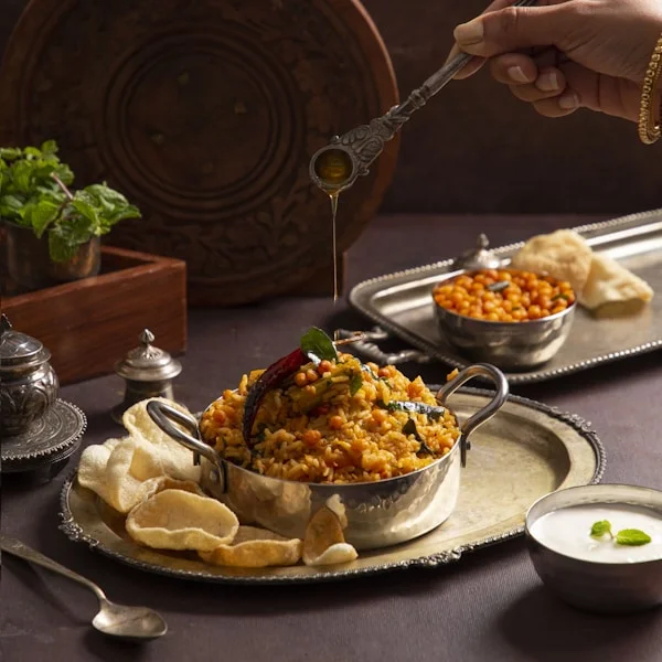 Fragrant vegetable biryani with saffron and crispy fried onions served on banana leaf